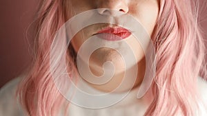 Beautiful red lips with a piece of sweet berry jelly candy. Close up of young woman with candy in mouth.