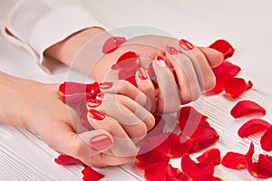 Beautiful red manicure and rose petals.