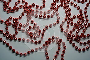 Beautiful red minor Christmas beads for decorating Christmas tree arranged on a white background.