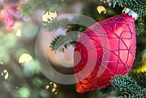 Beautiful red ornament on Christmas tree with sparkling white lights and soft background