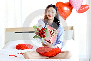 Beautiful red rose bouquet on Asian woman hand, girl showing Valentine flower present from lover boyfriend to camera while holding