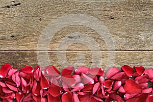 Beautiful red roses petals on wooden. Valentine's Day, anniversary etc background.