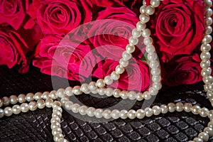 Beautiful red roses and white pearls. Concept of beauty for women. Background for valentines and woman day. Wedding decoration