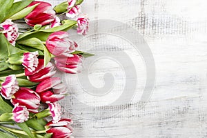 Beautiful red tulips and carnations on wooden table
