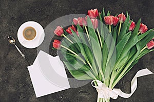 beautiful red tulips, cup of coffee and blank envelope with greeting card