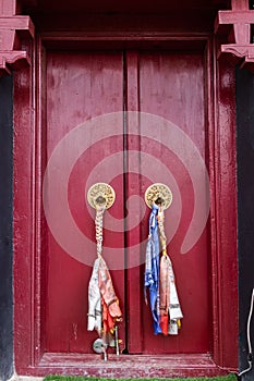 A beautiful red wooden door with brass knockers - culture concept.CR2