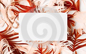 Beautiful red and yellow bird feathers and white blank paper mockup on corel background. Flat lay with copy space photo