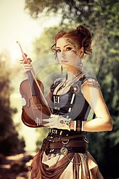 Beautiful redhair woman with body art on her face holding violin photo