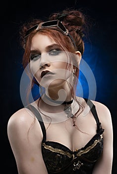A beautiful redhead cosplayer girl wearing a Victorian-style steampunk costume with big breasts in a deep neckline. Portrait. Blue