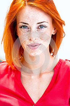 Beautiful redhead freckled woman smiling seductive, biting lips