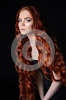 beautiful redhead girl with long hair. Perfect woman portrait on black background. Gorgeous hair and deep eyes Natural beauty