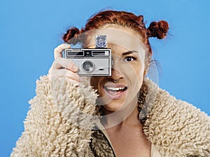 Beautiful redhead holding a vintage 35mm camera