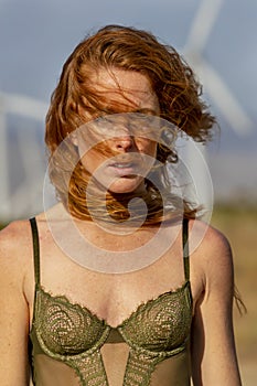 Sexy Redhead Model Posing Outdoors With Wind Turbines In The Background photo