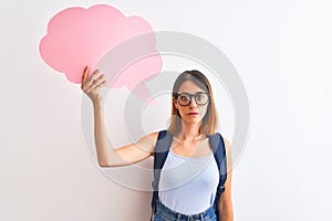 Beautiful redhead student woman wearing a backpack and holding speech bubble with a confident expression on smart face thinking