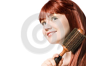 Beautiful redhead woman brushing her hair