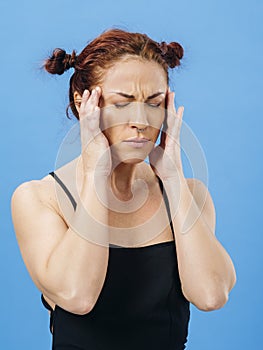 Beautiful redhead woman with headache over blue