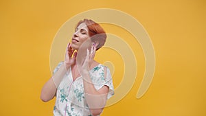 Beautiful redhead woman in her 40s listening to the music on headphones