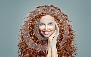 Beautiful redhead woman with long curly hair isolated on white. Haircare concept