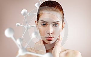 Beautiful redhead woman near big white molecule structure.