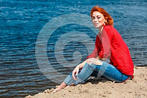Beautiful redhead woman sitting comfortably and smiling photo
