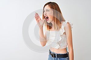 Beautiful redhead woman wearing casual t-shirt standing over isolated white background shouting and screaming loud to side with