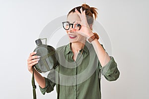 Beautiful redhead woman wearing glasses holding canteen over isolated white background with happy face smiling doing ok sign with