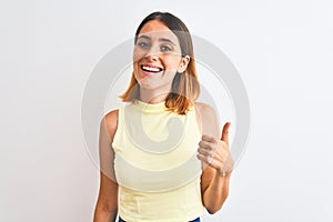 Beautiful redhead woman wearing yellow summer t-shirt over  background doing happy thumbs up gesture with hand