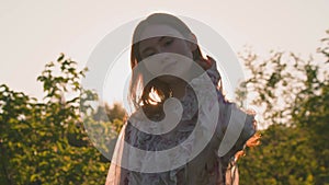 Beautiful redhead young girl fashion model posing in sunlight in summer meadow. Natural beauty. Handheld video