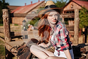 Beautiful redhead young woman cowgirl in hat