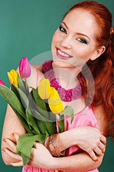 Beautiful redheaded girl is holding tulips