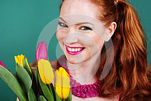 Beautiful redheaded girl is holding tulips