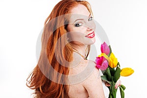 Beautiful redheaded girl is holding tulips