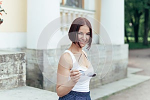 Beautiful redheaded girl lounging in the park and holding glasses