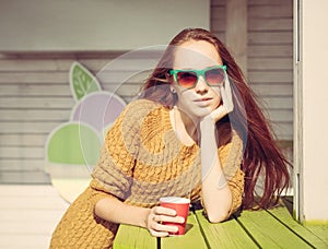 Beautiful redheaded girl in sunglasses for summer outdoor cafe table