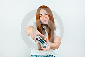Beautiful redheaded young women looks selfconfident standing on  white backgroung playing online exciting game with photo
