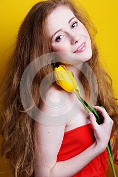 Beautiful redheared girl with bouquet of tulips