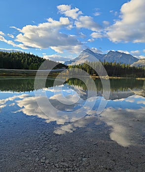Beautiful reflection of the mountains and the sky in the waters of a little pond.