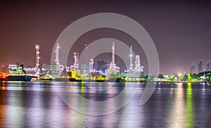 Beautiful reflection of Oil refineries located along the river with dark sky background-Image