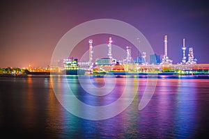 Beautiful reflection of Oil refineries located along the river with dark sky background-Image