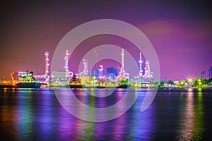 Beautiful reflection of Oil refineries located along the river with dark sky background-Image