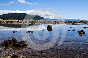 Beautiful reflections on beach along East Cape Road, New Zealand.