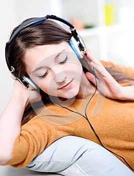 Beautiful relaxed young woman listening of the music by being le photo
