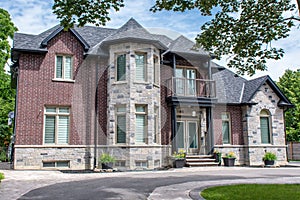 A beautiful residential executive home with brick and stone exterior, and a stone turret.