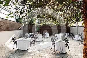 A beautiful restaurant with a transparent roof and decorated tables and live trees