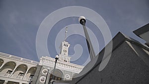 Beautiful restored building and a street lamp on blue sky background. Action. Bottom view of an antique church and a