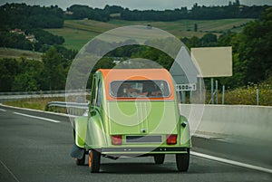 Beautiful retro car on a highway in the countryside. Summer, beautiful nature, green hills. Autotravel. Italy