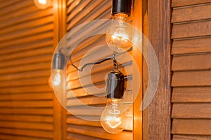 Beautiful retro luxury light lamp decor glowing.Decorative bulbs in vintage style Edison.Garland Light Bulb.Evening Wooden Stage