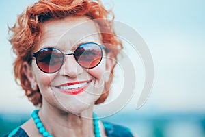 Beautiful retro older woman in front of the brick wall