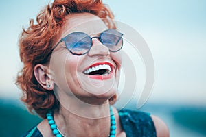 Beautiful retro older woman in front of the brick wall