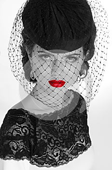 Beautiful retro woman portrait in elegant hat with red lips, beauty makeup. Black and white photo.